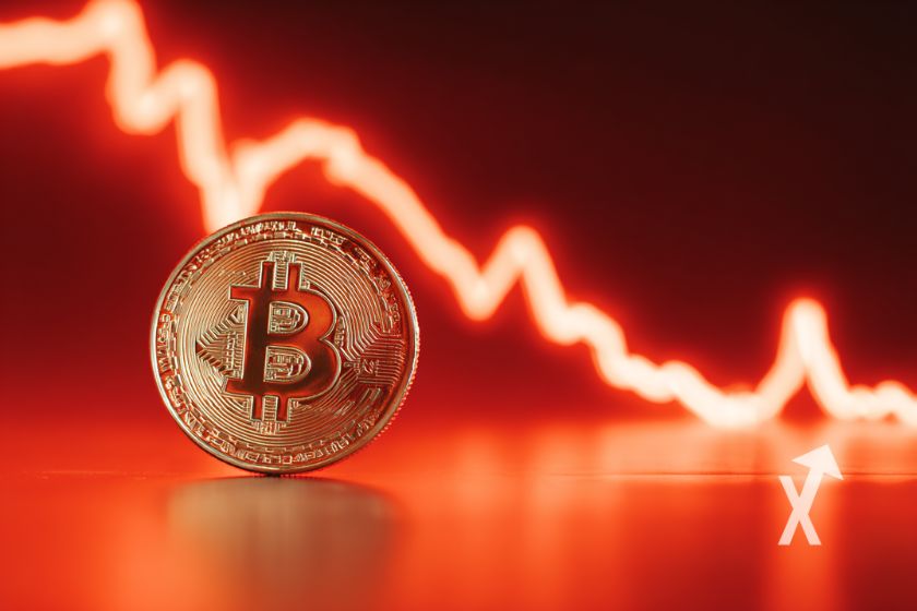 Bitcoin coin sur un fond rouge avec une trendline baissi&egrave;re rouge