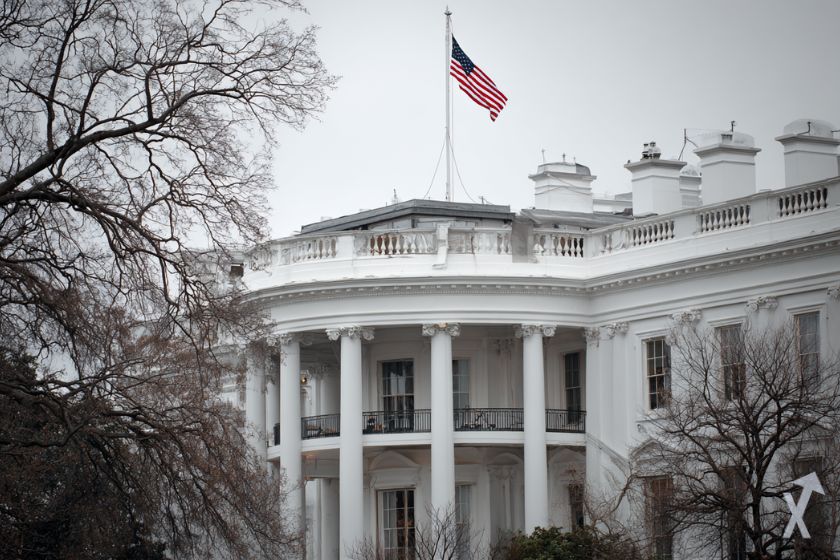 American white house with American flag, grey sky to represent the shutdown.