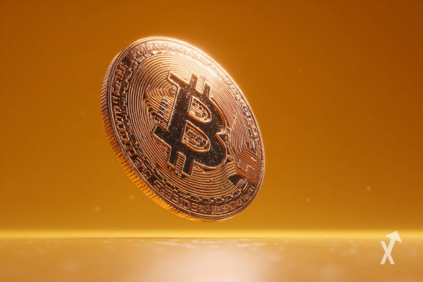 Bitcoin gigante sobre fondo naranja brillante.